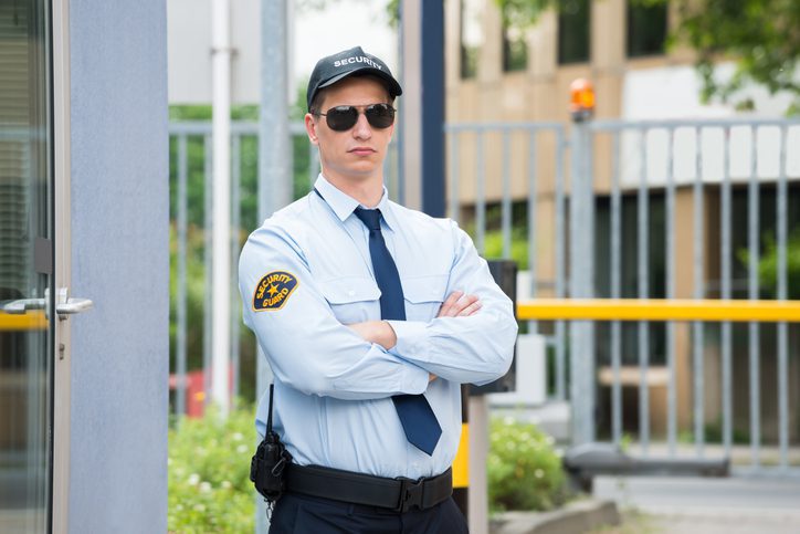 Security guard standing with arms crossed.